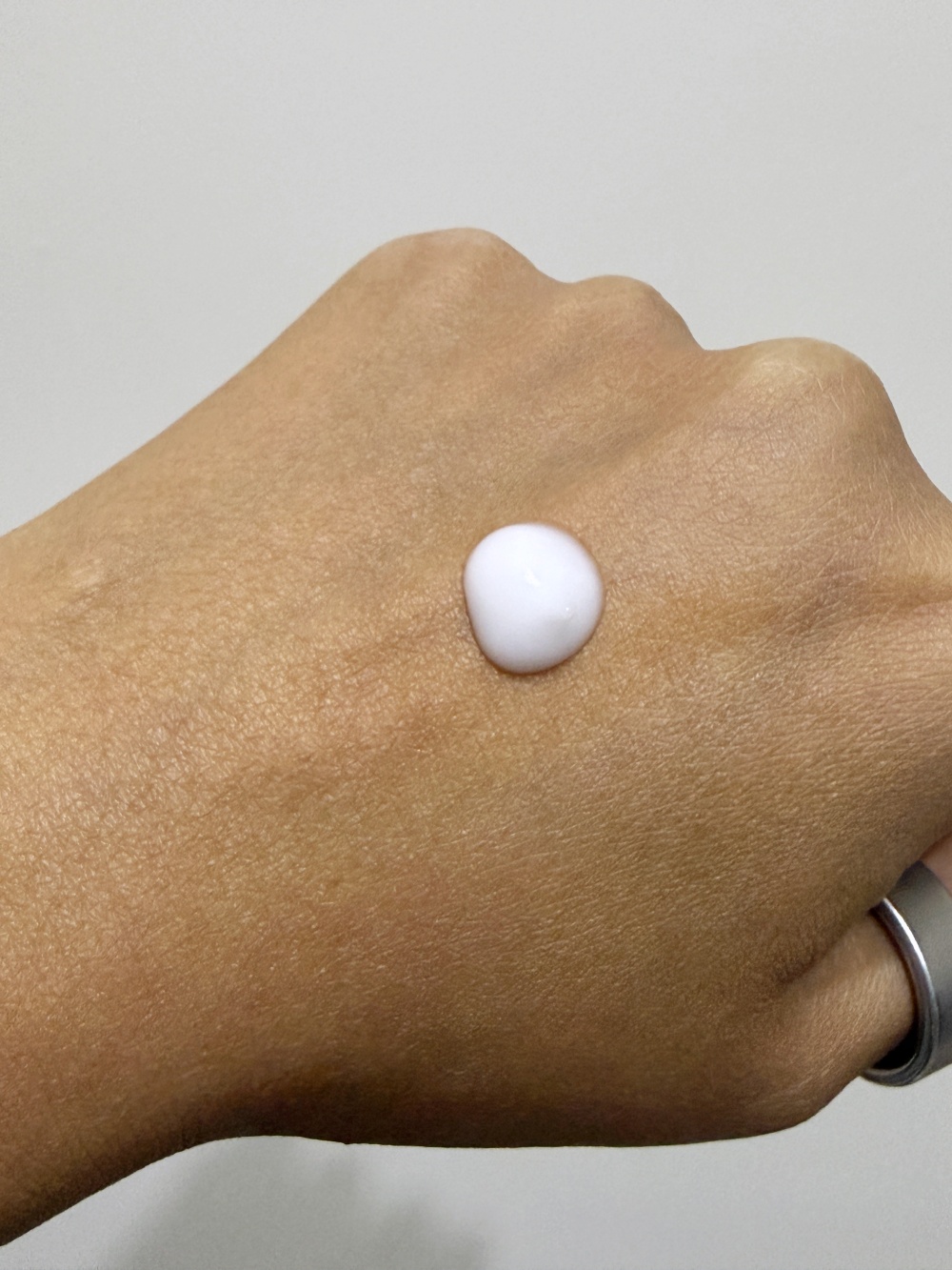 Hakme 展示 White Conc 柚子美白身體乳液擠在手背的輕盈 Lotion 質地，實測其清新柚子香氣
